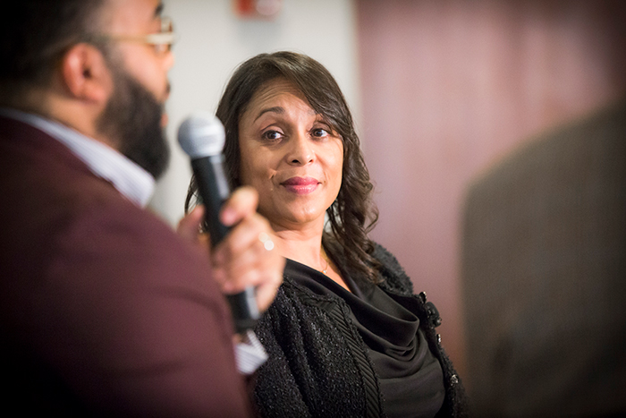 Natasha Trethewey listens as Kevin Young speaks at the "Neil Asks" event.