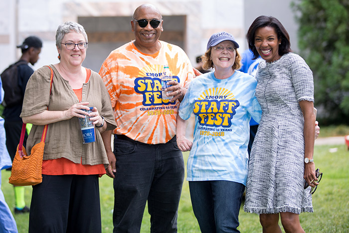 Staff members pose with Emory President Claire E. Sterk