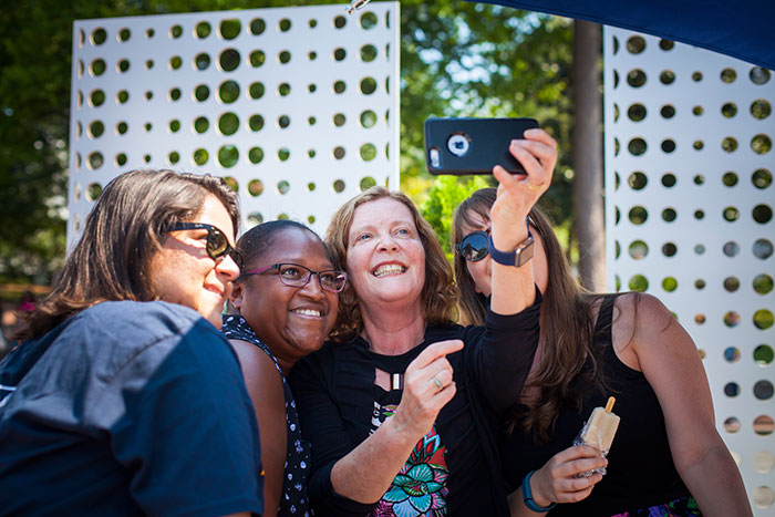 President Sterk takes a selfie with Emory staff members.