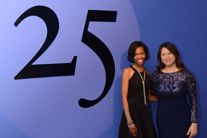two women standing in front of the number 25