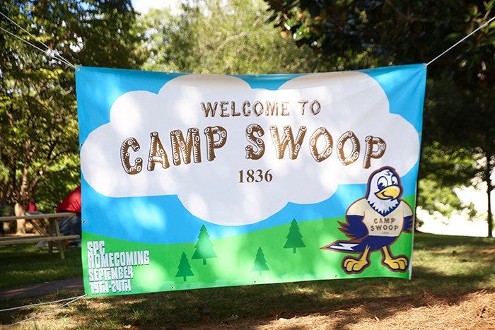 Camp Swoop banner hanging between trees.