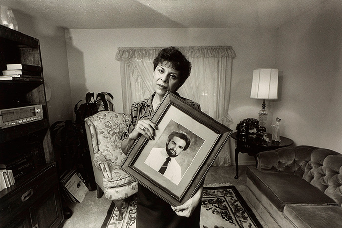 Woman holding picture of younger man