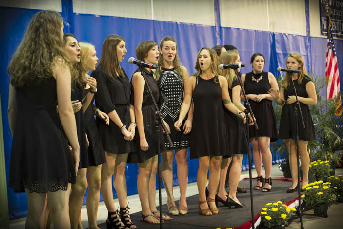 A group of women students performs a song on stage at the closing of the Carter Town Hall event.