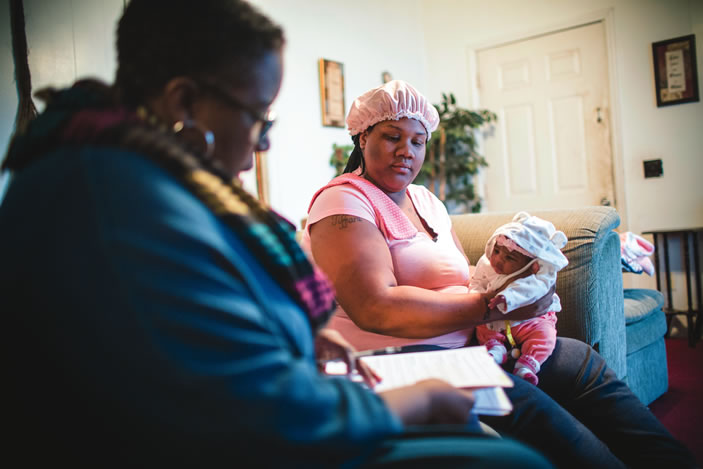 A team of School of Nursing researchers assess Tiunca Cameron's infant daughter, Tykeriah, at her home. 