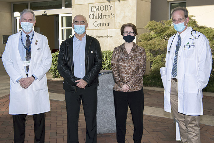 David S. Stephens, Moncef Slaoui, Nadine Rouphael and Evan Anderson pose in front of the Emory Children’s Center, where two COVID vaccine candidates (Moderna and Janssen) are being tested.