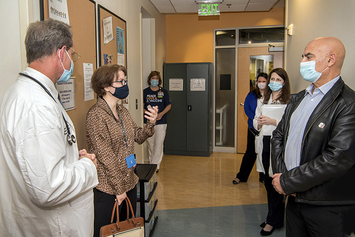 Nadine Rouphael speaks to Moncef Slaoui at the Emory Children’s Center as Evan Anderson and other clinic staff members look on.