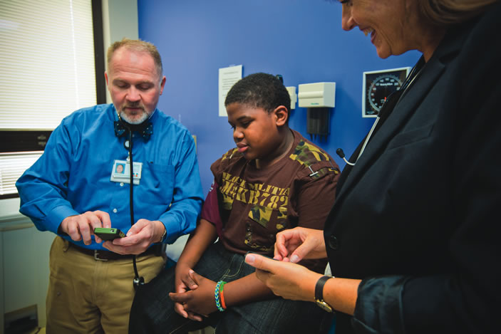 Donald Batisky uses the mobile app Pedia BP to assess patient James Robinson¿s blood pressure.
