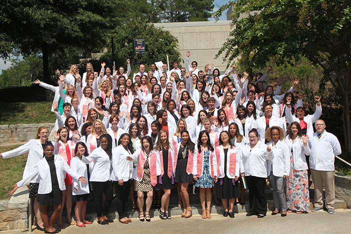The 111th graduate class of the School of Nursing gathers behind the Woodruff Health Sciences Center after the Pinning and White Coat Ceremony.