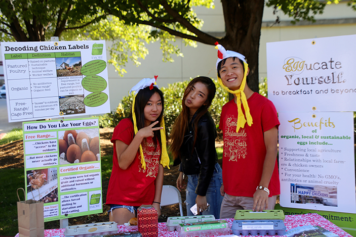 Students staffing chicken booth at sustainable food fair