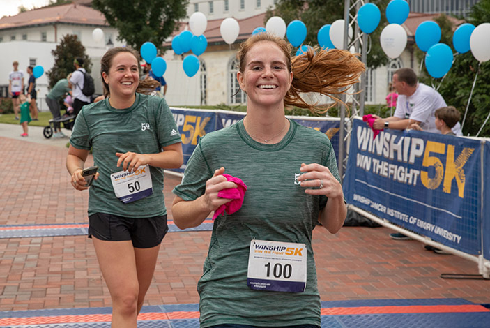 Two women smiling as they run