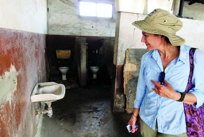Christine Moe examines a toilet facility in Accra, Ghana, where she and Clair Null are assessing the disease risk of poor sanitation.