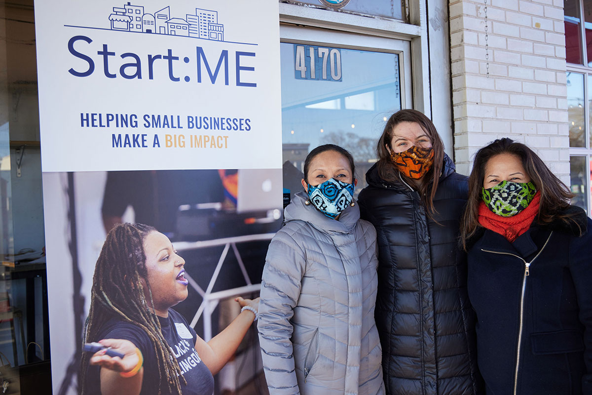 Students stand in front of a sign that says Start:ME