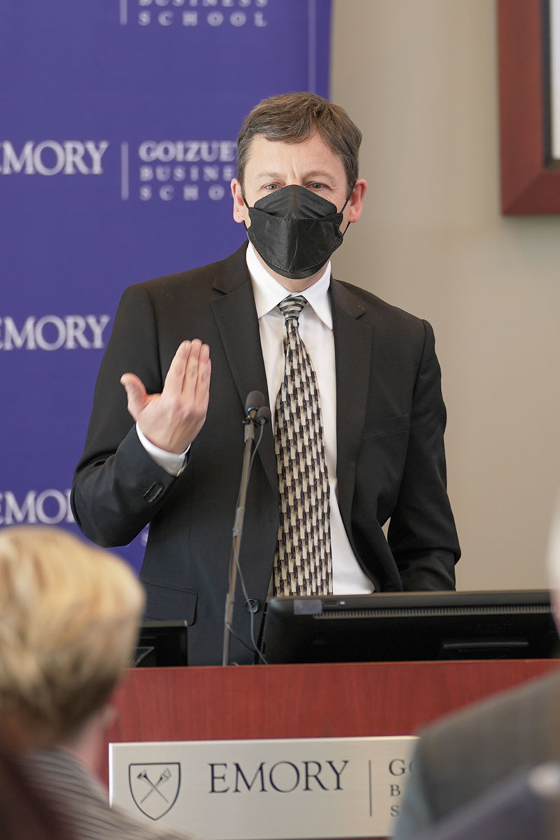 Gareth James speaks in front of a podium