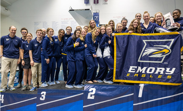 Group photo of the Emory Women's Swim and Dive Team holding a team banner.