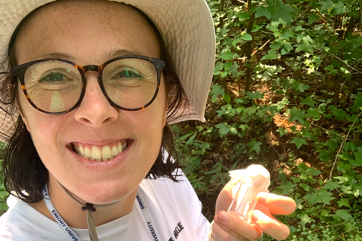 researcher with vial of ticks collected in the research field