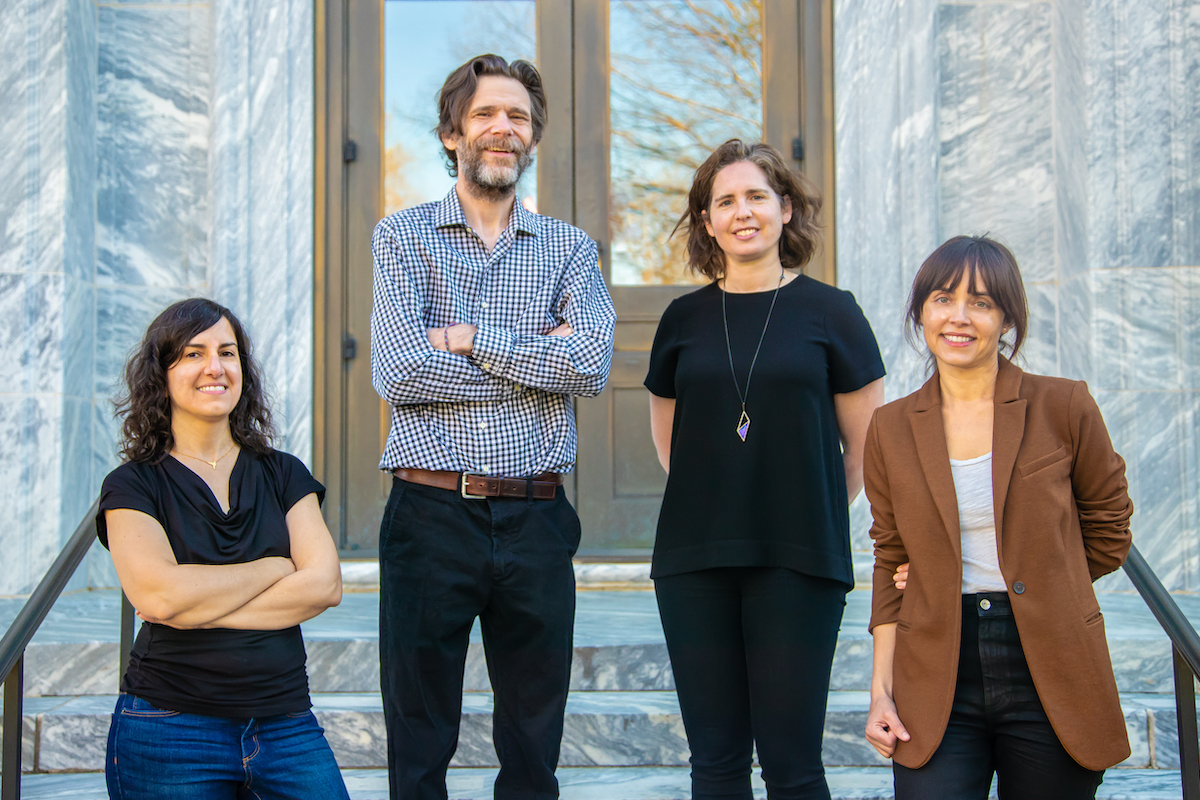 Portrait of Michal Arbilly, John W. Patty, Lauren Klein and Maggie Penn, standing on marble steps on Emory's quadrangle.