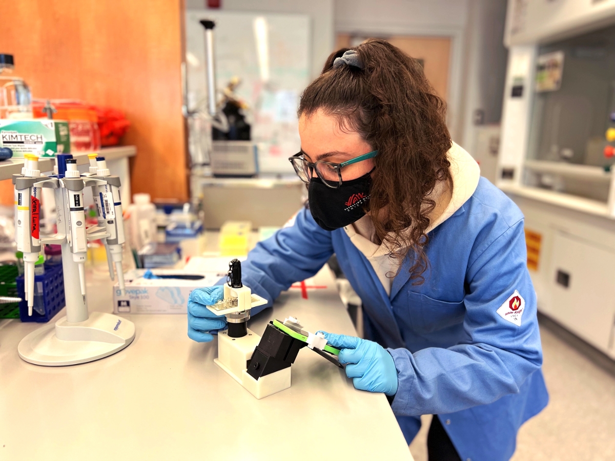 Emory graduate student Selma Piranej, shown in a lab setting with a cell-phone microscope
