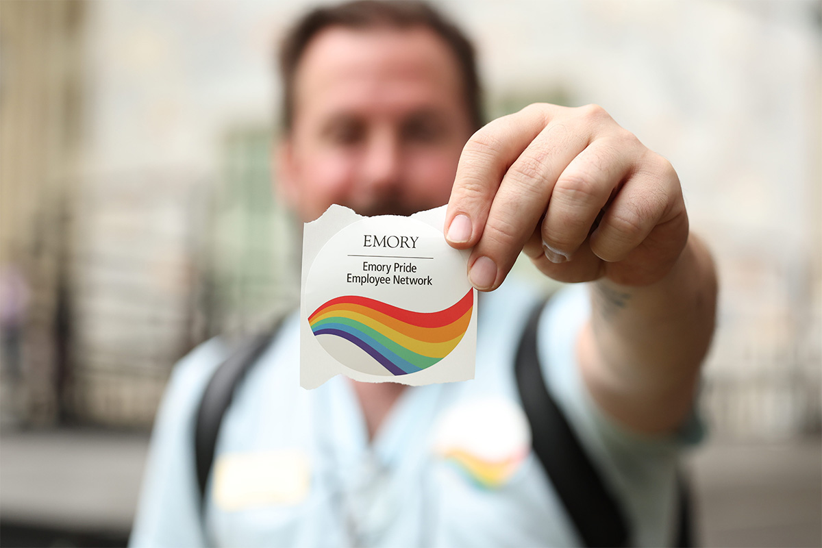 man holding Pride Month sticker