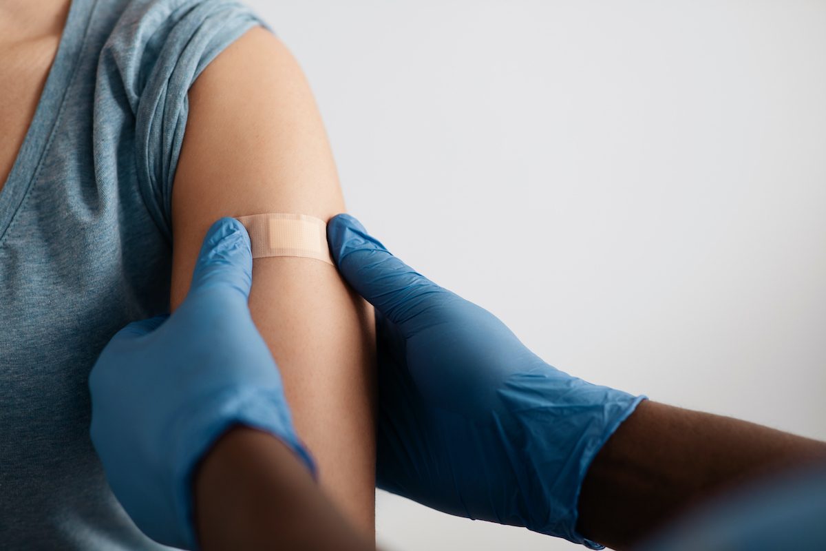 A band-aid is applied to an arm after a vaccine has been administered 