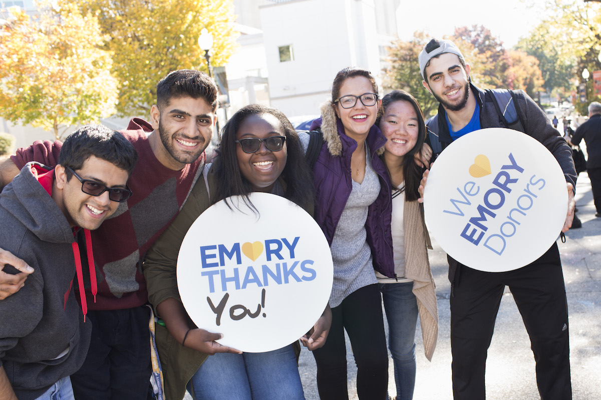 students holding emory thanks signs on emory campus